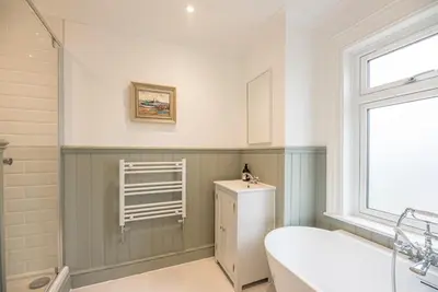 a bathroom with a sink and a toilet and a window at Millicent Cottage, Aldeburgh in Aldeburgh