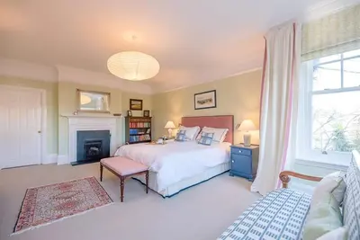 a bedroom with a large bed and a fireplace at Kingsfield House, Aldeburgh in Aldeburgh