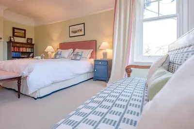 a bedroom with a large bed and a window at Kingsfield House, Aldeburgh in Aldeburgh