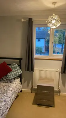 a bedroom with a bed and a window at Warm and Homely 4 Bed house w big Garden & Parking in Milton