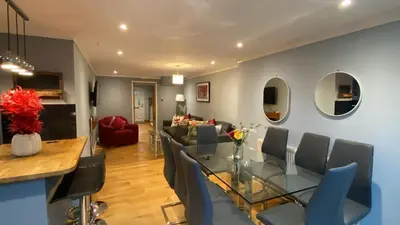 a dining room and living room with a glass table and chairs at Warm and Homely 4 Bed house w big Garden & Parking in Milton