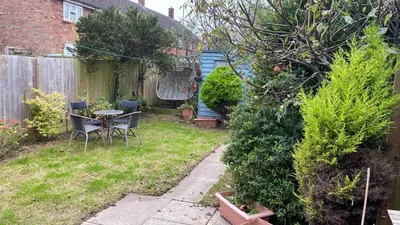 a garden with a table and chairs and a fence at Warm and Homely 4 Bed house w big Garden & Parking in Milton