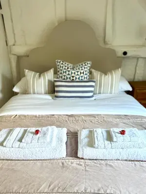 a bed with two white towels and pillows on it at Perfect country cottage retreat! in Fyfield