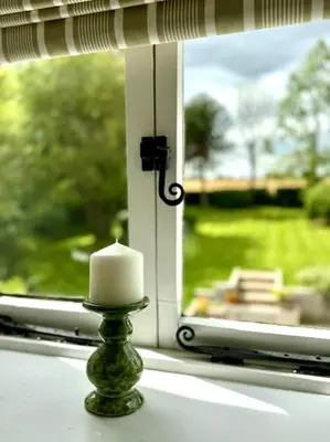 a candle in front of a window with a view at Perfect country cottage retreat! in Fyfield