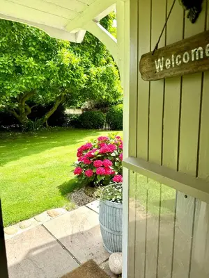 a welcome sign on the side of a house with flowers at Perfect country cottage retreat! in Fyfield