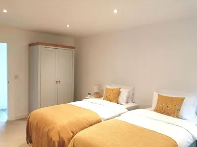 two beds sitting next to each other in a bedroom at The Highlands - 5 bed 5 bath - Huge Sociable House in Exning