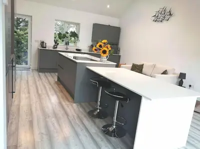 a kitchen with a large white island in a kitchen with a counter at The Highlands - 5 bed 5 bath - Huge Sociable House in Exning
