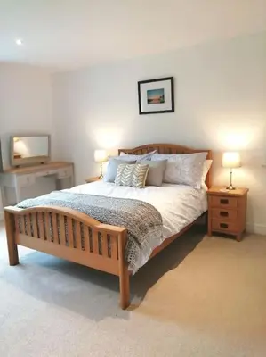 a bedroom with a bed with two night stands and two lamps at The Highlands - 5 bed 5 bath - Huge Sociable House in Exning