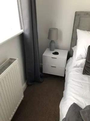 a bedroom with a bed and a night stand with a lamp at Modern house close to amenities St Ives Cambs in St Ives