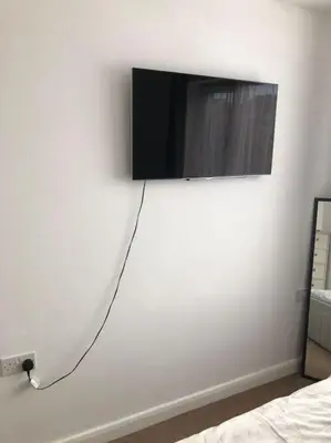 a flat screen tv hanging on a white wall at Modern house close to amenities St Ives Cambs in St Ives