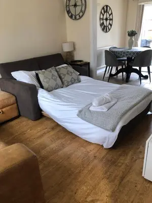 a large bed with towels on it in a living room at Modern house close to amenities St Ives Cambs in St Ives