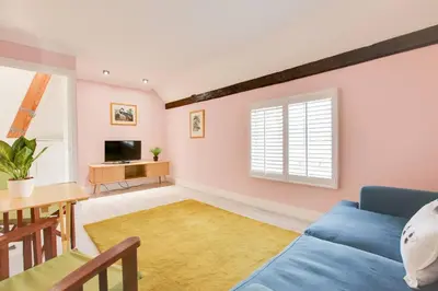 a living room with a blue couch and a table at Host My Nest - Historic 1BR 20 Mins to Stansted in Sawbridgeworth