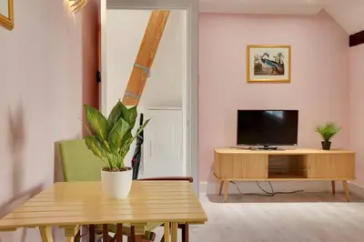 a living room with a table and a tv at Host My Nest - Historic 1BR 20 Mins to Stansted in Sawbridgeworth