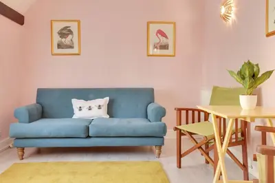 a blue couch in a living room with a table at Host My Nest - Historic 1BR 20 Mins to Stansted in Sawbridgeworth
