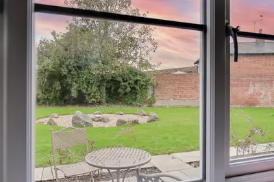 a window view of a yard with a table and chairs at The Kings Arms Rooms in Saint Osyth