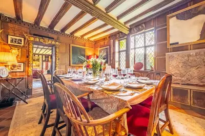 a dining room with a long table and chairs at Spectacular thousand year old Medieval manor house - Flemings Hall in Ipswich