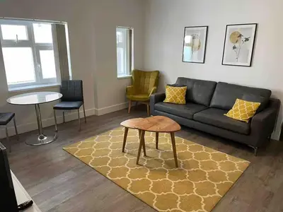 a living room with a couch and a table at Dream Yard Apartments Westcliff in Southend-on-Sea