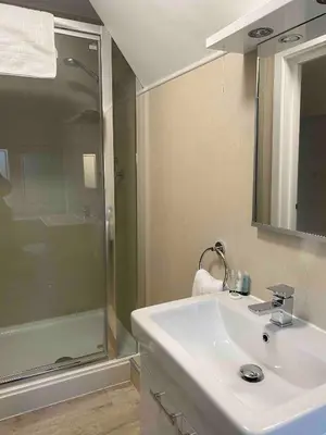 a bathroom with a white sink and a shower at Dream Yard Apartments Westcliff in Southend-on-Sea