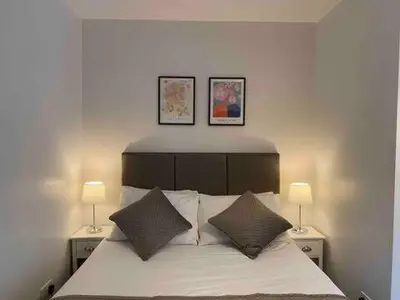 a bedroom with a bed with two lamps on it at Dream Yard Apartments Westcliff in Southend-on-Sea