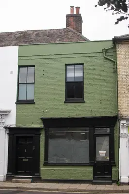 a green house with black windows on a street at Spacious Suffolk base in Saxmundham