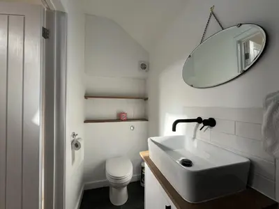a white bathroom with a sink and a mirror at Spacious Suffolk base in Saxmundham