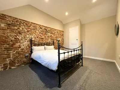 a bedroom with a brick wall and a bed at Spacious Suffolk base in Saxmundham