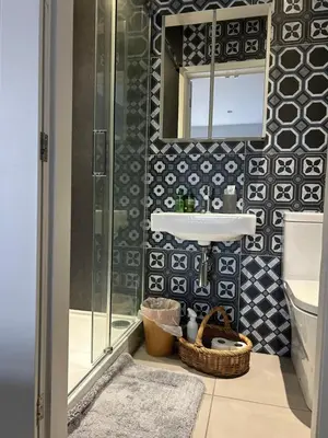 a bathroom with a sink and a mirror at Meadow Cottage in Trumpington