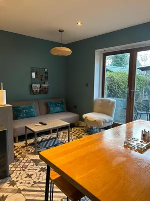 a living room with a couch and a table at Meadow Cottage in Trumpington