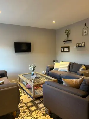 a living room with couches and a coffee table at Meadow Cottage in Trumpington