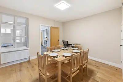 a dining room with a wooden table and chairs at Modern Family Home Waltham Abbey Free Parking in Waltham Abbey
