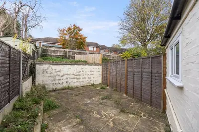 an empty backyard with a fence and a building at Modern Family Home Waltham Abbey Free Parking in Waltham Abbey