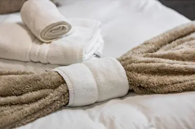 a pile of rolled towels on a bed at Modern Family Home Waltham Abbey Free Parking in Waltham Abbey