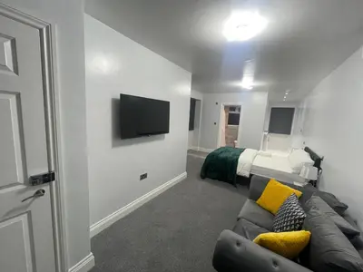 a living room with a couch and a bed at Premium studio flat rental in Havering atte Bower