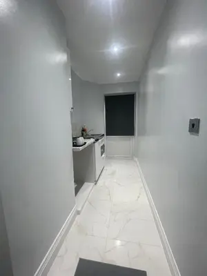 a white hallway with a sink and a kitchen at Premium studio flat rental in Havering atte Bower