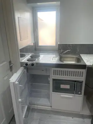 a small kitchen with a sink and a stove at Premium studio flat rental in Havering atte Bower