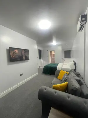 a living room with a couch and a bed at Cozy Studio Flat Romford, London in Romford