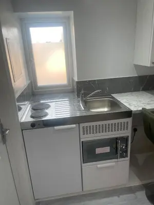 a small kitchen with a sink and a stove at Cozy Studio Flat Romford, London in Romford