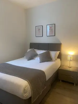 a bedroom with a large bed with two pillows at Dream Yard Apartments in Southend-on-Sea