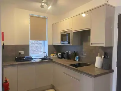 a kitchen with white cabinets and a counter top at Dream Yard Apartments in Southend-on-Sea