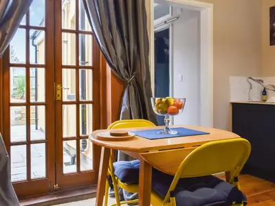 a table and chairs with a bowl of fruit on it at Ratcliffe Cottage in Ipswich