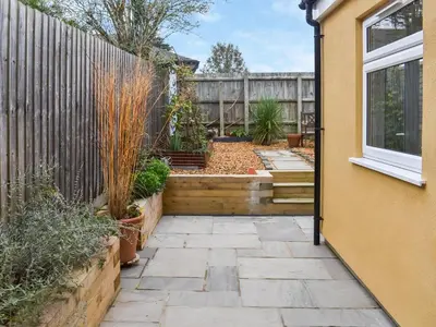 a garden with a fence and a patio at Ratcliffe Cottage in Ipswich