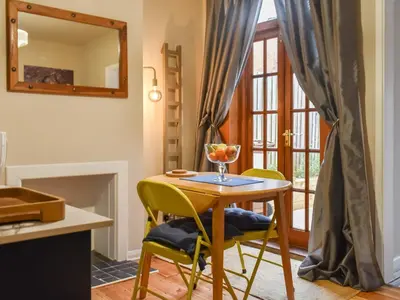a dining room with a table and chairs and a mirror at Ratcliffe Cottage in Ipswich