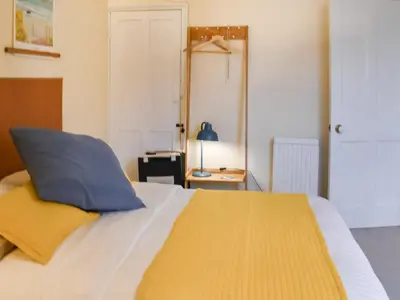 a bedroom with a bed with a blue and yellow pillow at Ratcliffe Cottage in Ipswich