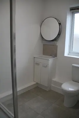 a bathroom with a toilet and a mirror at East Street Haven - Modern Apartment in Colchester in Colchester
