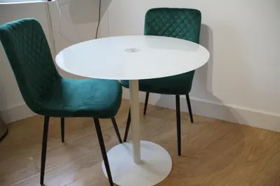 a white table with two green chairs next to it at East Street Haven - Modern Apartment in Colchester in Colchester