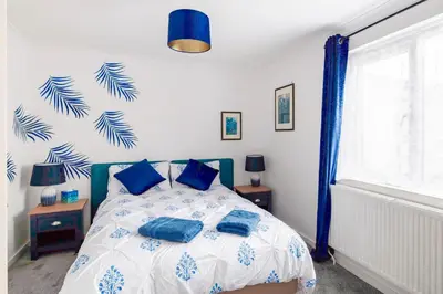 a bedroom with a blue and white bed with blue pillows at Comfortable 4-Bedroom Heaven in Thetford in Thetford