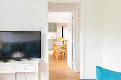 a living room with a television and a dining room at Comfortable 4-Bedroom Heaven in Thetford in Thetford