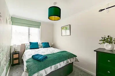a bedroom with a bed with blue pillows on it at Comfortable 4-Bedroom Heaven in Thetford in Thetford
