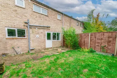 a brick building with a fence and a yard at Comfortable 4-Bedroom Heaven in Thetford in Thetford