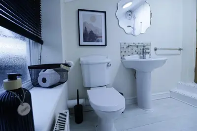 a white bathroom with a toilet and a sink at Stylish & Cosy Stay 2-Bed House Train Station Hospital Garden Fast WiFi in Colchester